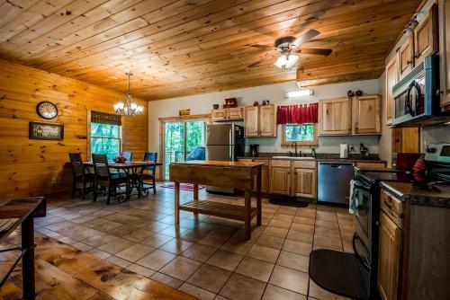 a kitchen with wooden cabinets and a table in a cabin at Sunrise Summit | Deluxe 2BR 2.5BA Cabin | Mountain View | Private | Hot Tub in Sautee Nacoochee, Georgia in Sautee Nacoochee