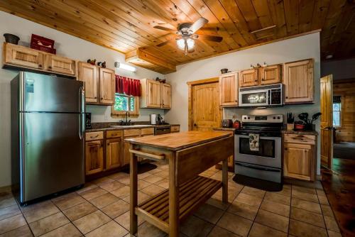 a kitchen with a stainless steel refrigerator and a wooden ceiling at Sunrise Summit | Deluxe 2BR 2.5BA Cabin | Mountain View | Private | Hot Tub in Sautee Nacoochee, Georgia in Sautee Nacoochee