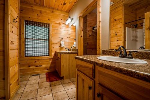 a bathroom with a sink in a wooden cabin at Sunrise Summit | Deluxe 2BR 2.5BA Cabin | Mountain View | Private | Hot Tub in Sautee Nacoochee, Georgia in Sautee Nacoochee