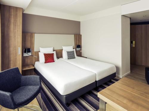 a hotel room with a bed and a chair at Mercure Hotel Nijmegen Centre in Nijmegen