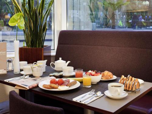 a table with plates of breakfast food on it at Novotel Sheffield Centre in Sheffield