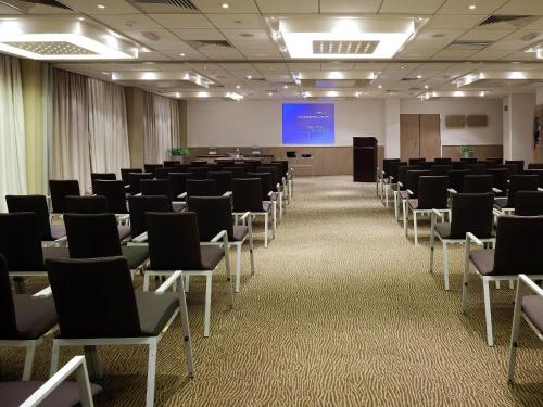 a room with rows of chairs and a podium at Novotel Sheffield Centre in Sheffield