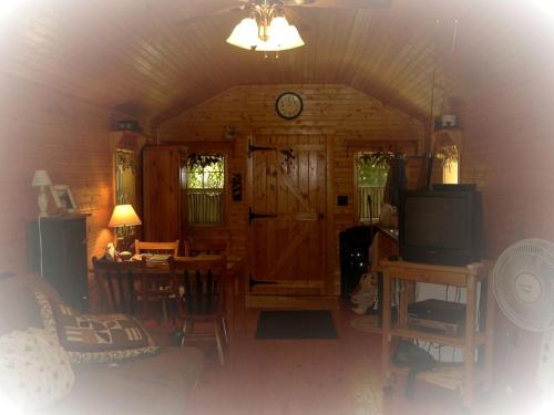 a living room with a tv and a dining room at Romantic Cabin Rental with Wi-Fi near Lake Ontario in Sackets Harbor, New York in Sackets Harbor