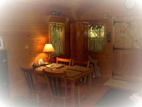 a dining room with a wooden table and chairs at Romantic Cabin Rental with Wi-Fi near Lake Ontario in Sackets Harbor, New York in Sackets Harbor
