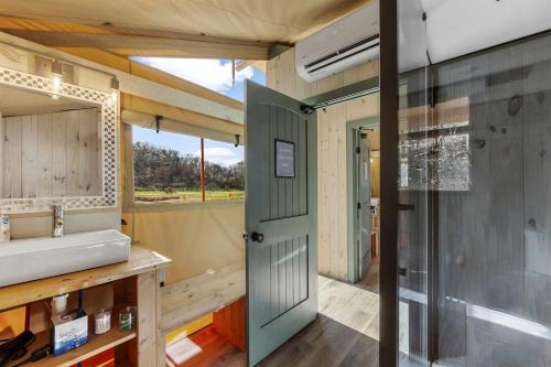 un baño con ducha y lavabo en Radiant Safari Tent Escape near Smoky Mountains in Tennessee, en Parrottsville