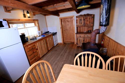 a kitchen with a refrigerator and a table and chairs at Secluded Cabin Rental with Mountain Views in Clark, Northern Colorado in Columbine