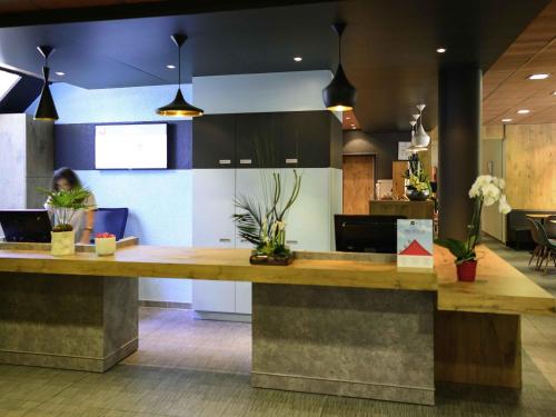 a woman sitting at a reception desk in a lobby at ibis Avignon Centre Pont De L'Europe in Avignon