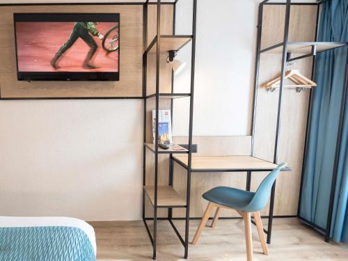 a room with a desk and a chair and a tv at ibis Avignon Centre Pont De L'Europe in Avignon