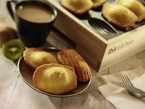a plate of donuts next to a box with a cup of coffee at ibis Avignon Centre Pont De L'Europe in Avignon
