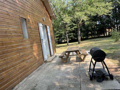 a barbecue grill and picnic table next to a building at Hébergements le Camp d'Auneau - Aunay Bien in Auneau