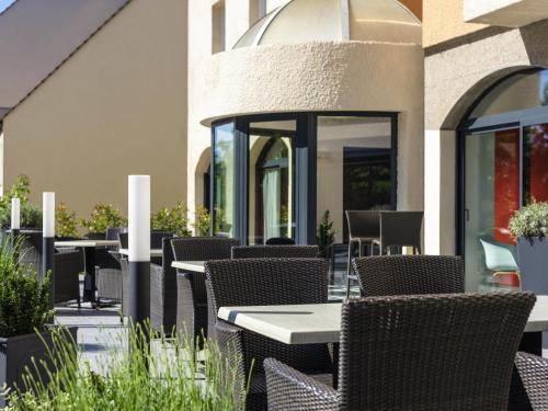 an outdoor seating area with tables and chairs at ibis Beaune Centre in Beaune