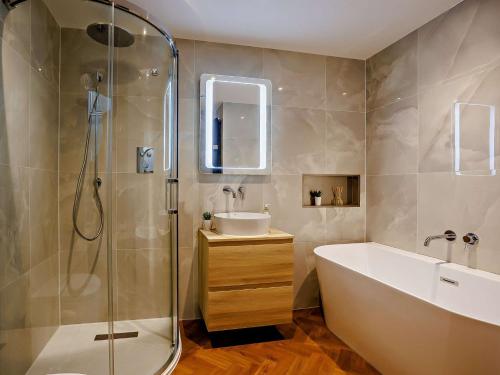 a bathroom with a tub and a sink and a shower at 4 Bed in Westward Ho 86640 in Bideford