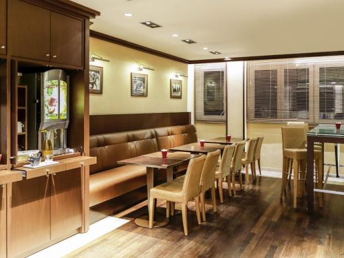 a restaurant with tables and chairs in a room at ibis Besançon Centre Ville in Besançon
