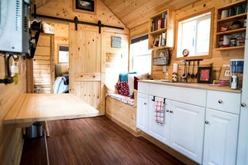 a kitchen in a tiny house with wooden walls at Comfortable Tiny House Rental near Fairbanks for Pet-Friendly Glamping in Alaska in Chena River Seaplane Base