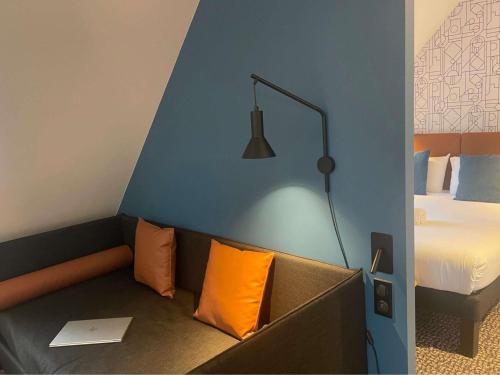 a room with a couch with a bed and a lamp at ibis Colmar Centre in Colmar