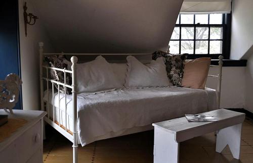 a white bed with pillows and a table in a room at Private Bed and Breakfast Accommodation for Two near Doylestown, Pennsylvania in Buckingham
