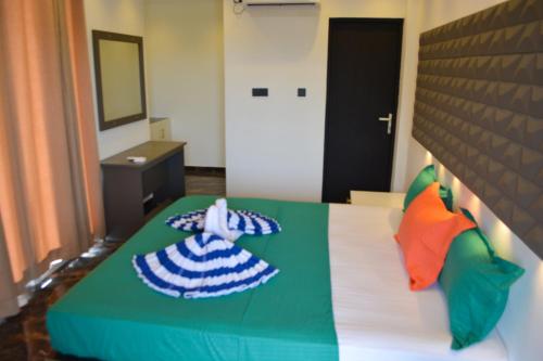a bedroom with a bed with colorful pillows on it at Radiance Hotel in Trincomalee