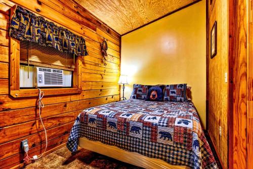 ein Schlafzimmer mit einem Bett in einer Holzhütte in der Unterkunft Cozy Creekside Cabin Rental near Cherokee, North Carolina in Cherokee