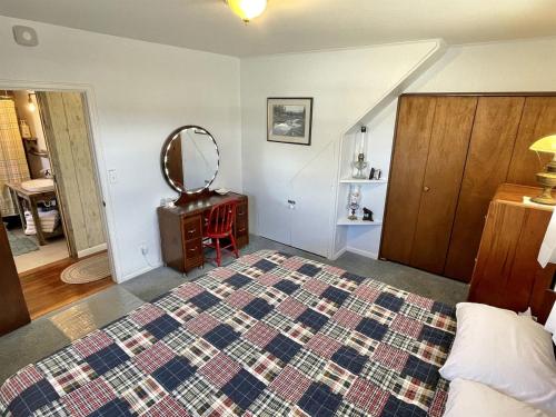 une chambre avec un grand lit et un miroir dans l'établissement Stunning Cottage with Fire Pit in Saratoga, Wyoming, à Encampment