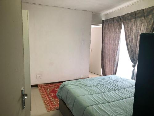 a bedroom with a bed and a window at Simons Town Cove Guest House in Simonʼs Town