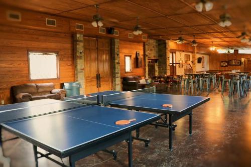 two ping pong tables in a room with chairs at Rest and Relax in Texas in this Great Safari Tent Getaway in Cibolo in Marion