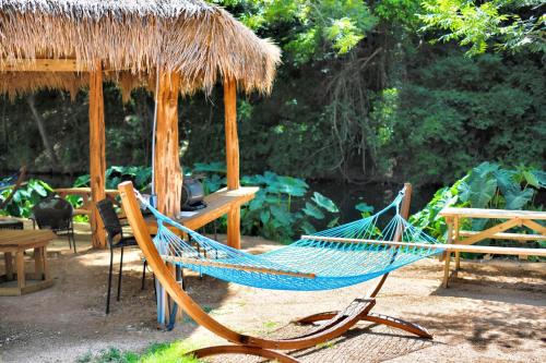 a blue hammock sitting in front of a hut at Rest and Relax in Texas in this Great Safari Tent Getaway in Cibolo in Marion