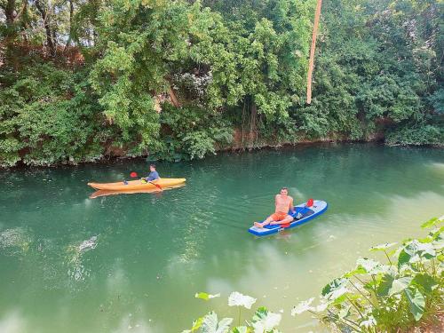 three people are sitting on kayaks in a river at Rest and Relax in Texas in this Great Safari Tent Getaway in Cibolo in Marion