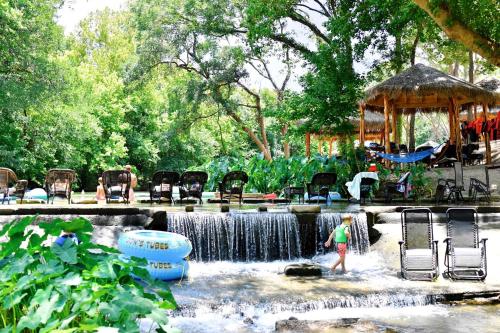 a person standing in front of a waterfall in a park at Rest and Relax in Texas in this Great Safari Tent Getaway in Cibolo in Marion