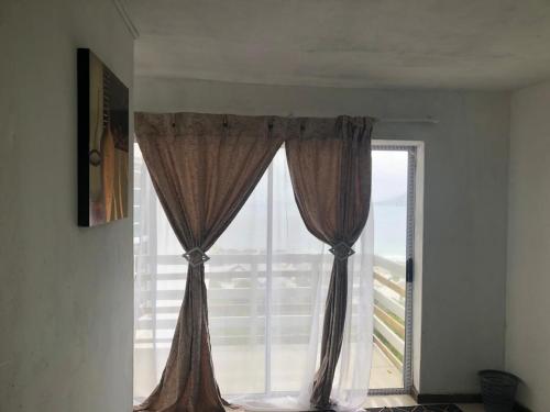 a window with brown curtains in a room at Simons Town Cove Guest House in Simonʼs Town