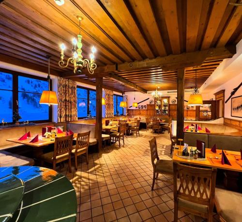 a restaurant with wooden ceilings and tables and chairs at Andi's Skihotel in Obertauern