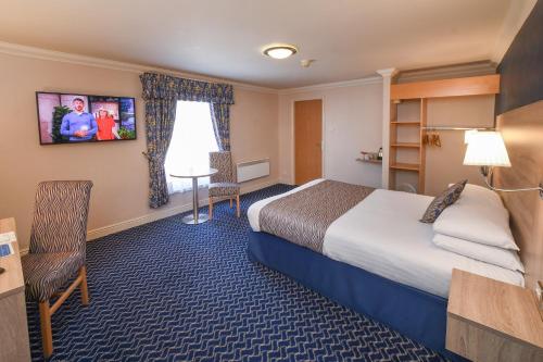 a hotel room with a bed and a desk at The Queens Hotel & Victoria Cloisters Apartments in York