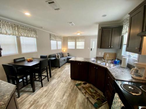 a kitchen and living room with a table and a couch at Picturesque Cottage with Fire Pit in Dunnellon, Florida in Dunnellon