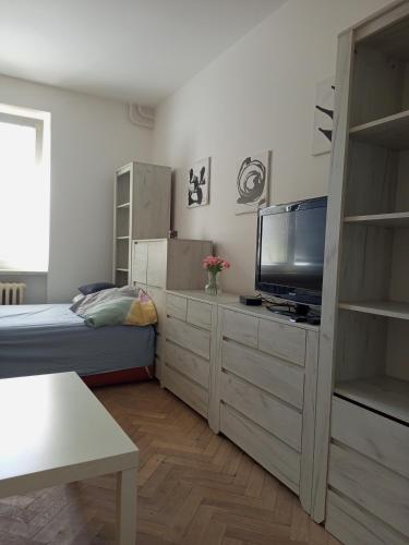 a small bedroom with a bed and a television at Flat Břeclav City Center in Břeclav