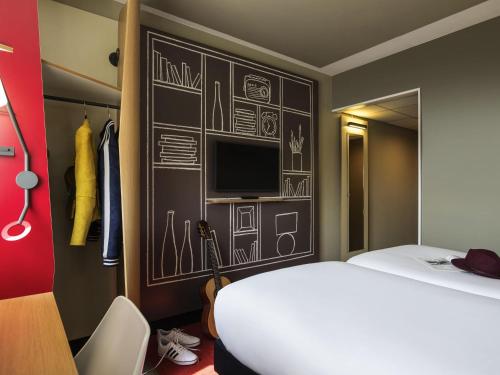 a bedroom with a bed and a wall with drawings on it at ibis Dijon Gare in Dijon