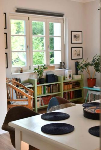 a living room with a table with chairs and windows at Grafit vendégház in Nagyrákos