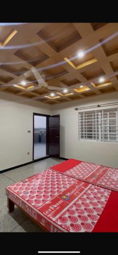 a room with a bed with a red bedspread on it at Twin City Club in Rawalpindi