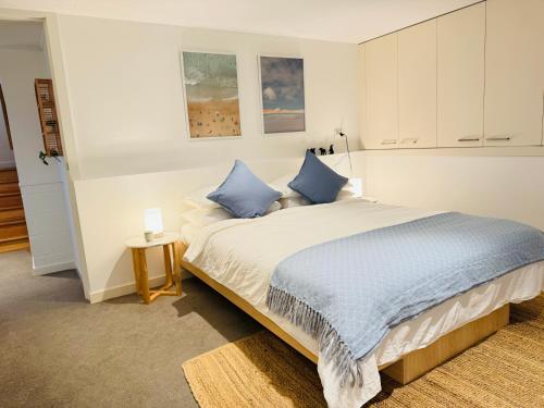 a bedroom with a large bed with blue pillows at RYE HOLIDAY AWAY in Rye