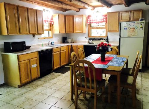a kitchen with a table and a refrigerator at Pet-Friendly Cabin Retreat in the Ozarks of Scenic Newton County, Arkansas in The Basin
