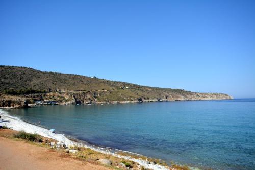 a beach with a bunch of people on the shore at Olea in Pirgos Dhirou