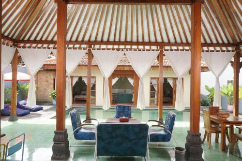 a pavilion with chairs and a table and a dining room at Villa Joglo Kawung - City Centre Paradise with Pool in Yogyakarta