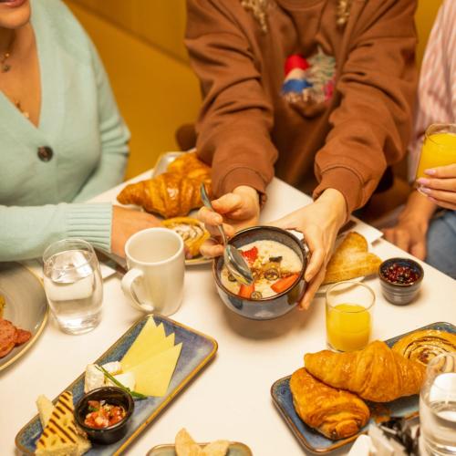 a group of people sitting at a table with food at Maldron Hotel Finsbury Park, London in London