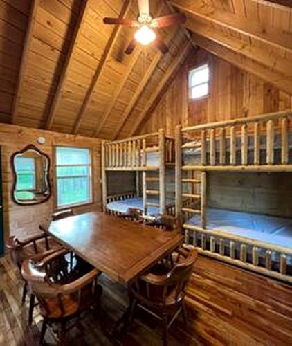 a dining room with a table and two bunk beds at Secluded Riverside Cabin for 8 in Belfast, NY with Rustic Amish-Built Retreat in Oramel