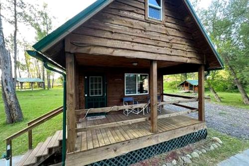 a small log cabin with a porch and a deck at Secluded Riverside Cabin for 8 in Belfast, NY with Rustic Amish-Built Retreat in Oramel