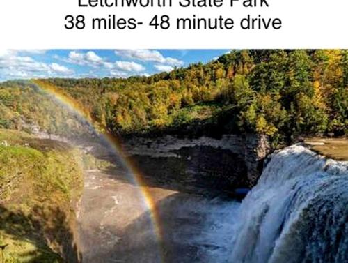 a large waterfall with a rainbow in the middle at Secluded Riverside Cabin for 8 in Belfast, NY with Rustic Amish-Built Retreat in Oramel