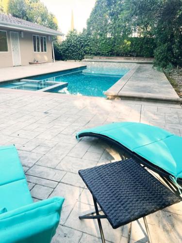 Hidden Hillsにある3BR Villa with Serene Poolside Views - CAL1 - HHのパティオ(テーブル、プールサイドのパラソル付)