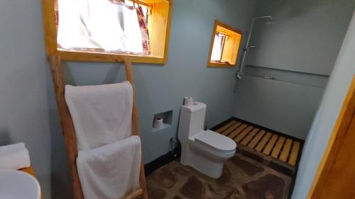 a small bathroom with a toilet and a window at Akagera Park Inn in Akagera