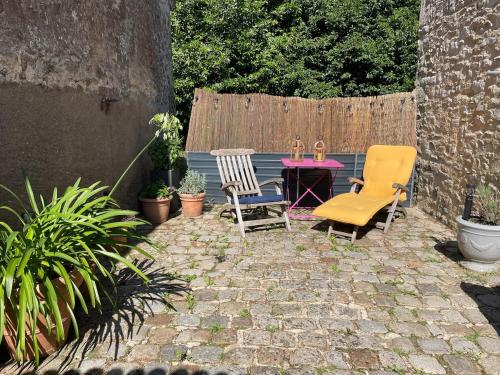 un patio con due sedie e un tavolo di Charming little house a Sainte-Reine-de-Bretagne