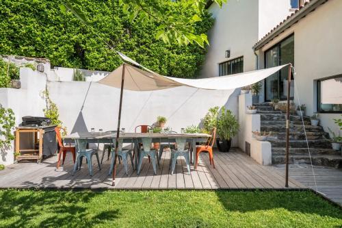 un patio con tavolo, sedie e tenda di Le Pressoir - Newly refurbished house with contemporary decoration a Saint-Cyr-au-Mont-dʼOr