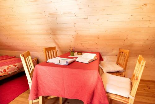 a room with a red table and chairs in a cabin at Cozy Cabin in Triglav National Park for Family Getaways in Slovenia in Soča