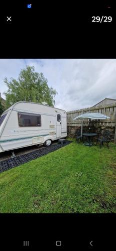 a white trailer parked in a yard next to a table at Parkhouse farm caravan in Easby